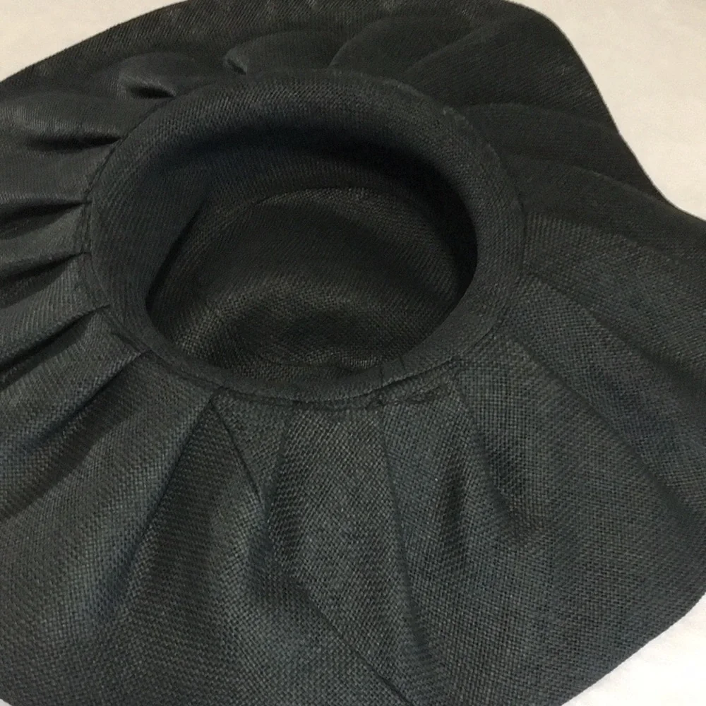 Woman’s black wide brim floppy burlap type hat with red bow.